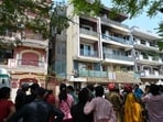 A crowd gathers outside the residential building after a fire broke out, killing nine people, at Vivek Vihar in New Delhi.(HT Photo)