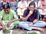 The protesters were seen sitting in a line outside the secretariat, with grass kept on a paper before them