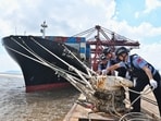 Police officers check the mooring lines of a vessel ahead of Typhoon Dolphin in Beilun District of Ningbo City, east China's Zhejiang Province, on Friday. (File Photo/AP)