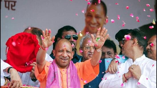 Chief minister Yogi Adityanath showering flowers on Kanwariyas in Meerut on Saturday. (ANI PHOTO)