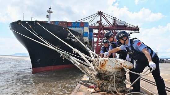 Police officers check the mooring lines of a vessel ahead of Typhoon Dolphin in Beilun District of Ningbo City, east China's Zhejiang Province, on Friday.