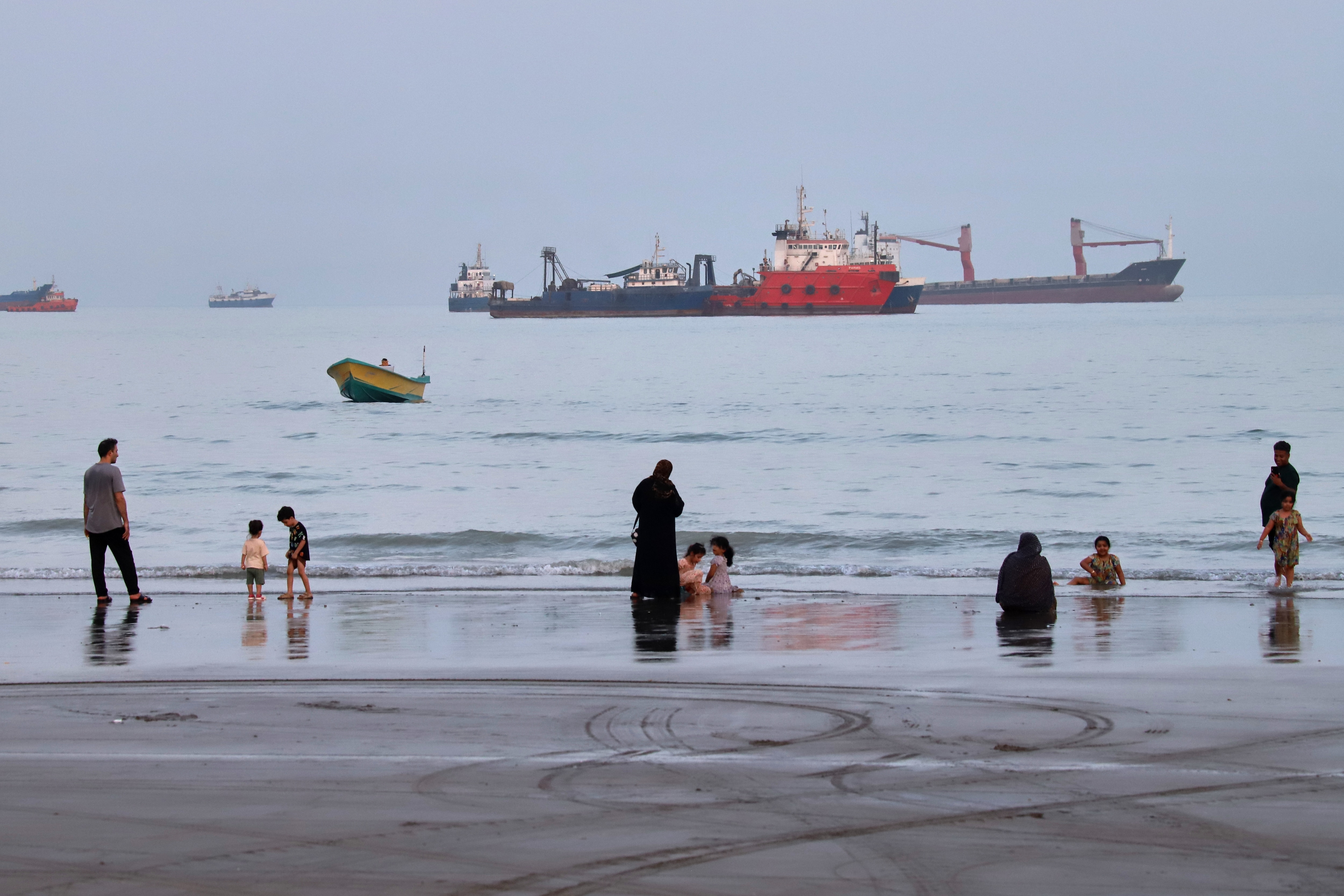 People spend time at a beach as commercial vessels are anchored in the Strait of Hormuz off Bandar Abbas, Iran. (ISNA via AP Photo) People spend time at a beach as commercial vessels are anchored in the Strait of Hormuz off Bandar Abbas, Iran. (ISNA via AP Photo)