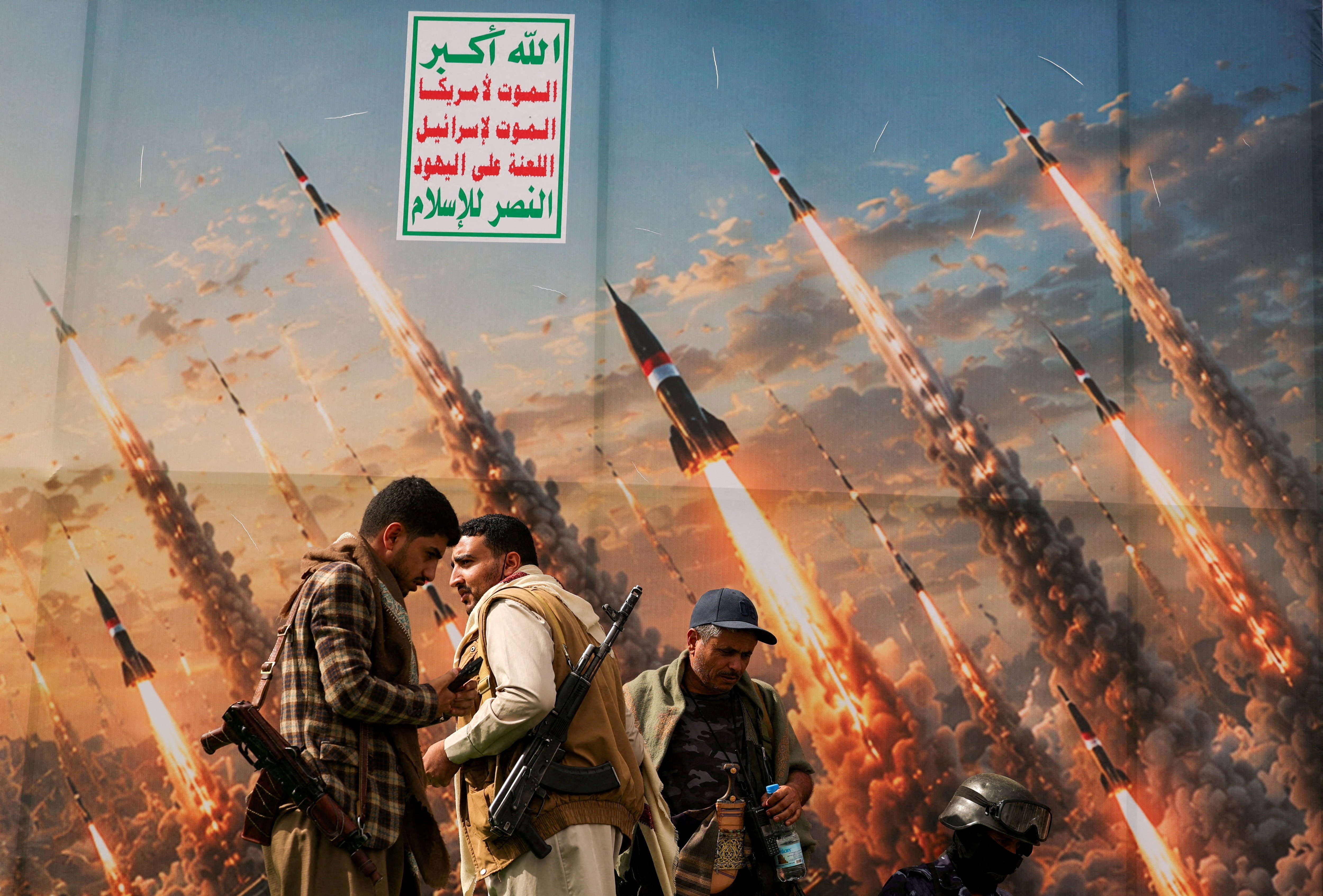 Houthis stand on a platform against a banner depicting Houthi missiles, at an anti-Saudi rally amid an escalation with the kingdom, in Sanaa, Yemen. (Reuters)