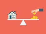 Home and stack of money on the scale (Getty Images/iStockphoto)