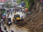 An earth mover clears debris from a road following a landslide triggered by rainfall in Shimla on Tuesday, July 28.
