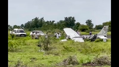 Local residents and officials gather around the wreckage of a trainer aircraft that crash-landed near the airstrip at Baramati Airport, in Pune district, Maharashtra, Sunday. (PTI) Local residents and officials gather around the wreckage of a trainer aircraft that crash-landed near the airstrip at Baramati Airport, in Pune district, Maharashtra, Sunday. (PTI)