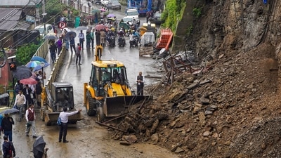 An earth mover clears debris from a road following a landslide triggered by rainfall in Shimla on Tuesday, July 28. (PTI)