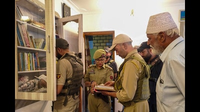 Security officials conduct a search operation in connection with a UAPA case registered against banned organisation Jamaat-e-Islami (JeI), in Sopore, Jammu and Kashmir, on Sunday. (PTI)