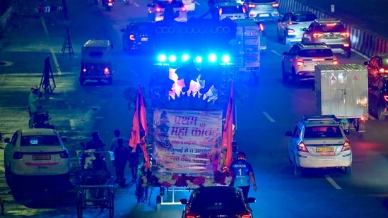 Boomboxes blare music as Kanwariyas, devotees of Lord Shiva, carry holy water from the River Ganges during the annual Kanwar Yatra along NH 24 near Akshardham.