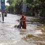 Kolkata: A woman wades through the waterlogged street of south Kolkata due to heavy rainfall, in Kolkata on Wednesday. (ANI Photo)