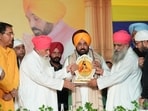 Dera Sachkhand Ballan spiritual head Sant Niranjan Dass (left) presenting a memento to Punjab chief minister Bhagwant Mann in Jalandhar on Sunday. (HT)