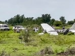 Local residents and officials gather around the wreckage of a trainer aircraft that crash-landed near the airstrip at Baramati Airport, in Pune district, Maharashtra, Sunday. (PTI)