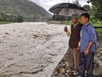 People look at the swollen Beas river as the water level rises following incessant monsoon rain, in Kullu, Himachal Pradesh.(PTI)