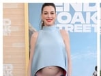 Anne Hathaway flaunts her baby bump fashionably well on the red carpet for The End of Oak Street world premiere. 