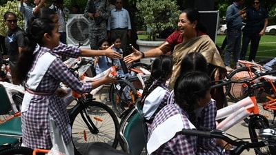 Delhi Chief Minister Rekha Gupta greets girl students as they leave with their bicycles after she flags off the distribution of free bicycles to students enrolled in Delhi government schools under the Vidya Vahini Yojana at the Delhi Legislative Assembly  in New Delhi, India on Monday.