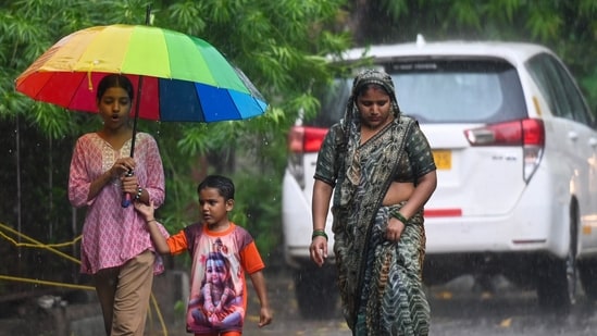 Commuters were seen moving about during the rain in the afternoon in Noida.