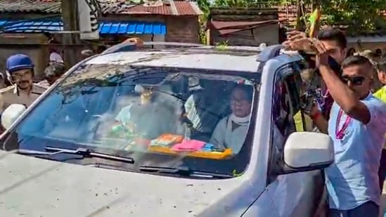 Security officials and police personnel form a protective wall around the vehicle carrying former West Bengal Chief Minister and Trinamool Congress (TMC) chief Mamata Banerjee as agitated demonstrators attack her convoy (PTI)