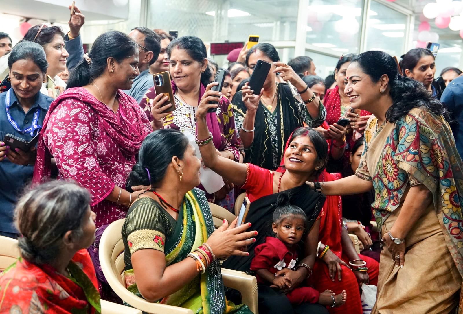 Delhi Chief Minister Rekha Gupta poses for a selfie with beneficiaries during the inauguration of the registration portal for the Delhi Lakshmi Yojana. (@gupta_rekha/X)