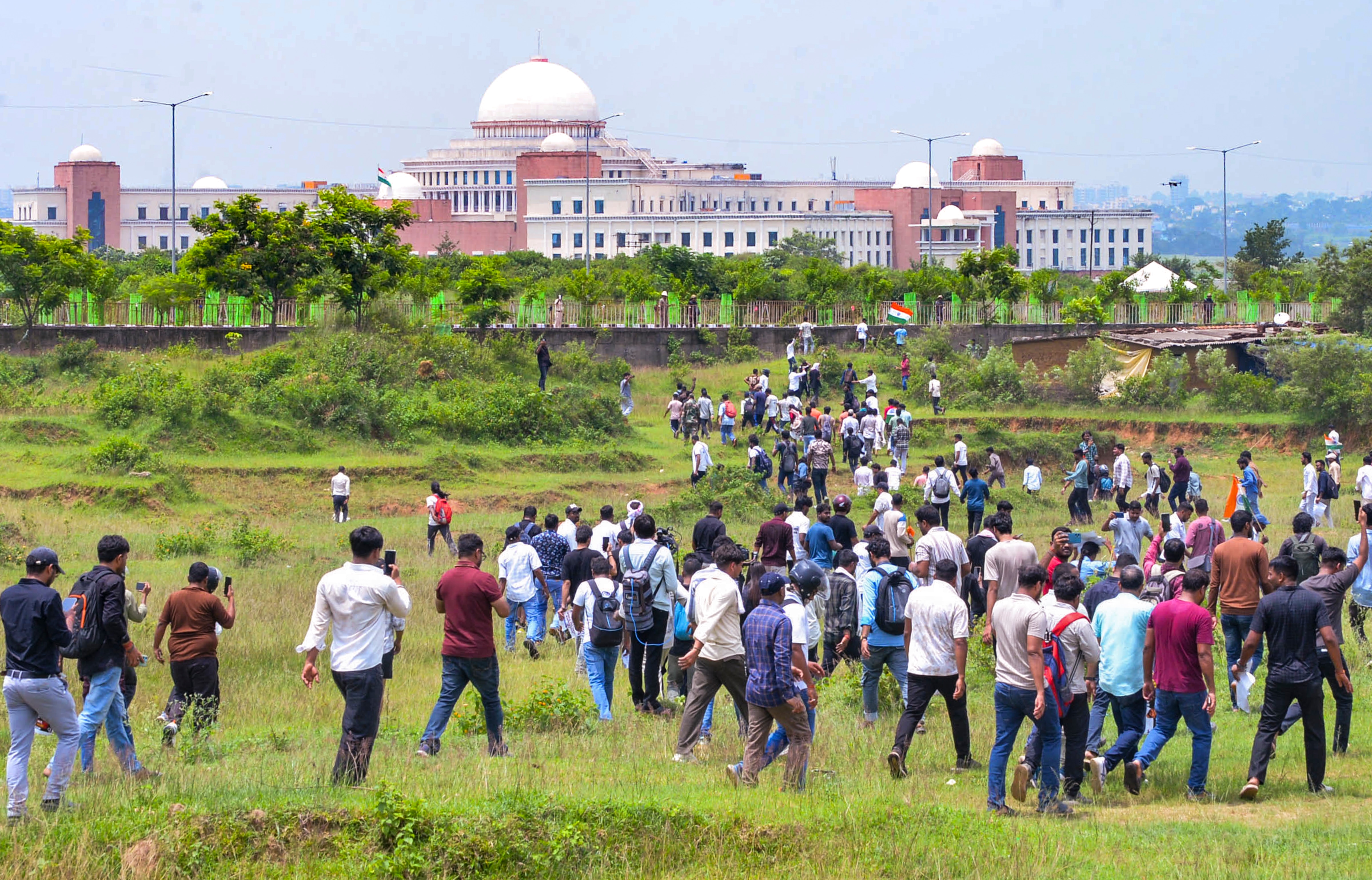 Protestres march through open fields towards the Jharkhand legislative assembly building to register their protest against the state government over alleged paper leaks and recruitment irregularities. (PTI) Protestres march through open fields towards the Jharkhand legislative assembly building to register their protest against the state government over alleged paper leaks and recruitment irregularities. (PTI)