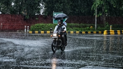 A commuter on a two-wheeler passes through a rain-slicked road amid heavy rainfall, in New Delhi. (ANI Photo) A commuter on a two-wheeler passes through a rain-slicked road amid heavy rainfall, in New Delhi. (ANI Photo)