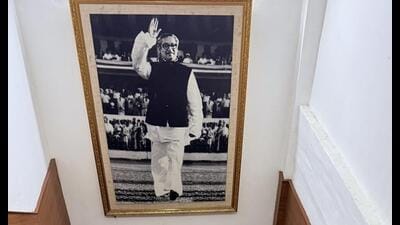 In the black-and-white photograph, Sheikh Mujibur Rahman is raising a hand in greeting. In the black-and-white photograph, Sheikh Mujibur Rahman is raising a hand in greeting.