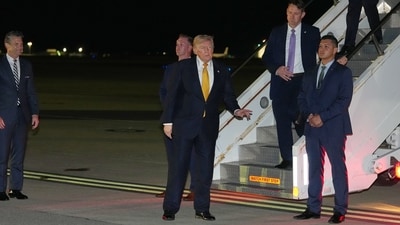 As Defense Secretary Pete Hegseth watches at left, President Donald Trump gestures as he switches planes at US Air Force Base, RAF Mildenhall in Suffolk Eastern England, on his way back to Washington from the NATO summit in Ankara, Turkey, Wednesday, July 8, 2026. (AP Photo)