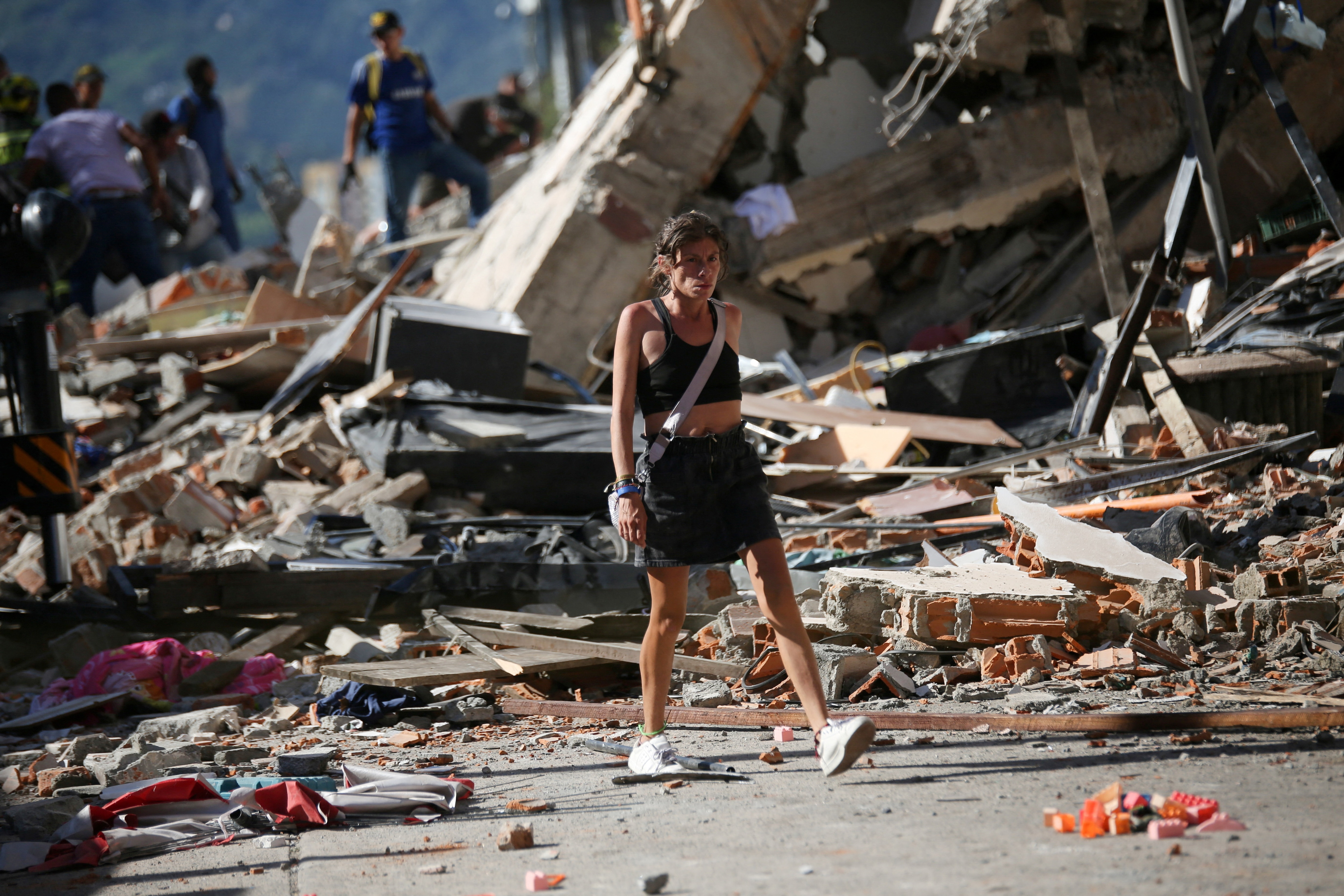 A woman walks past the debris of collapsed buildings after an earthquake, in Pereira, Colombia, (REUTERS)