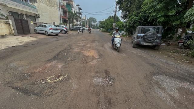 A damaged internal road in Sushant Lok-2 near Huda Market, seen on Tuesday. (Parveen Kumar/HT)