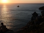 A tourist looks at the sunset the day before the solar eclipse, on the Costa da Morte ("Coast of Death"). 