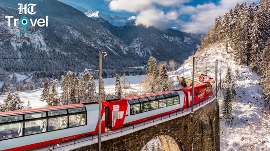 A scenic Swiss train winds through dramatic Alpine landscapes, offering travellers a memorable way to experience Switzerland at a slower pace.