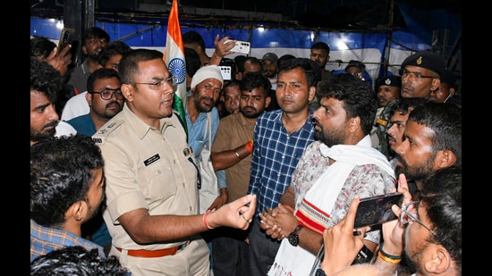 Police officers interact with protesting students as they urge them to clear the Jaipal Singh Munda Stadium, where they have been demonstrating for the last few weeks against the Jharkhand government regarding JPSC-JSSC-CGL paper leak issues, in Ranchi, Wednesday midnight (PTI)