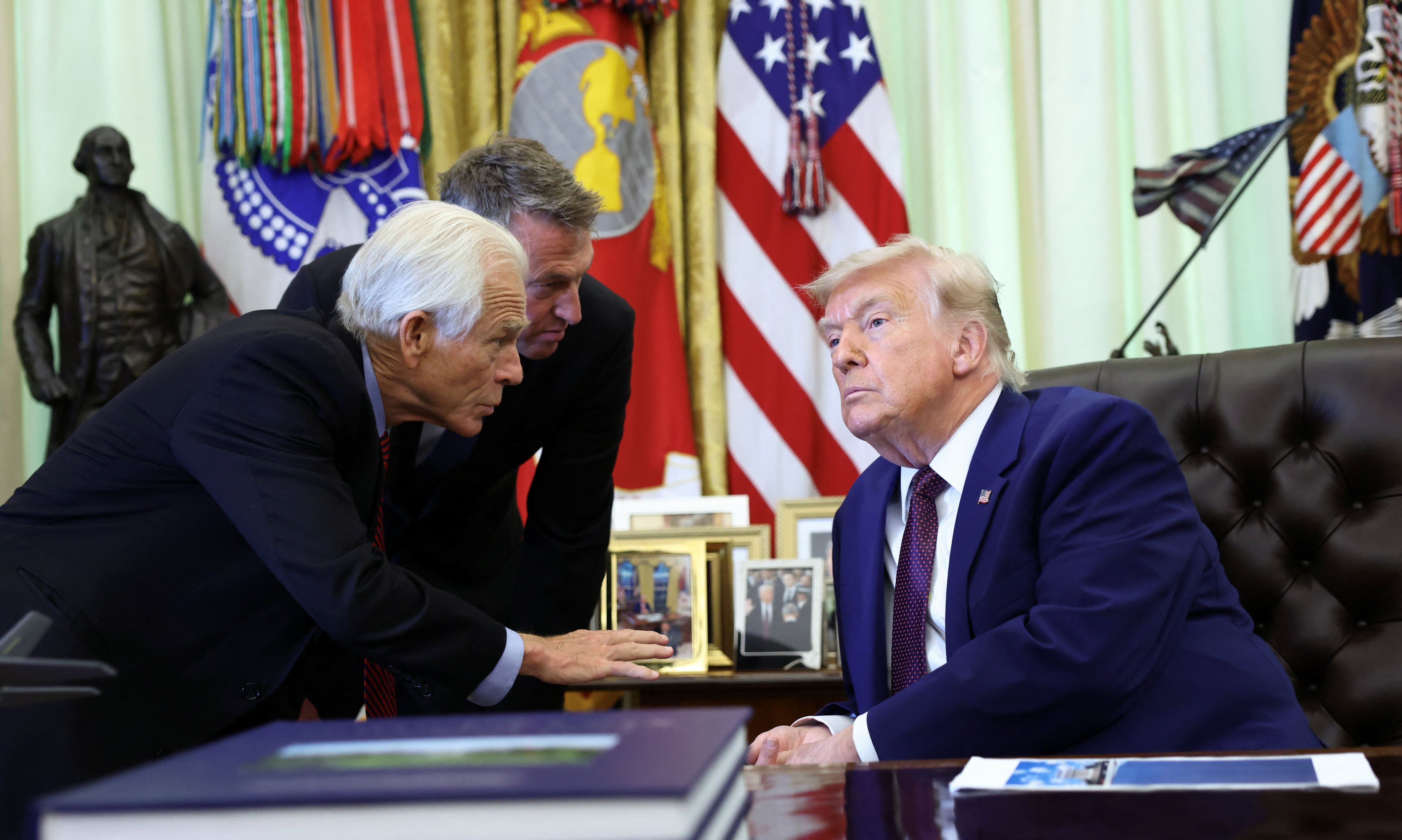 Us President Donald Trump speaks with trade and manufacturing adviser Peter Navarro in the Oval Office of the White House in Washington, DC. (REUTERS)