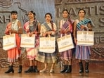 Surrendered women naxals pose for a group picture during their participation in a Tribal fashion show programme organised to mark National Handloom Day, in Raipur.