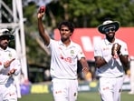 Bangladesh bowler Hasan Mahmud (C) holds the ball aloft after taking six wickets against Australia.