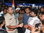Police officers interact with protesting students as they urge them to clear the Jaipal Singh Munda Stadium, where they have been demonstrating for the last few weeks against the Jharkhand government regarding JPSC-JSSC-CGL paper leak issues, in Ranchi, Wednesday midnight (PTI)