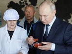 Russian President Vladimir Putin tastes products as he visits the Yasny fish processing complex at Kitovoye village on the Iturup Island, the largest of the Kuril Islands.