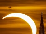 The moon partially covers the sun during a solar eclipse over the Prague Castle, as seen from Prague, Czech Republic,.
