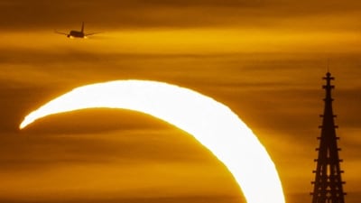 The moon partially covers the sun during a solar eclipse over the Prague Castle, as seen from Prague, Czech Republic,.