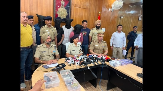Police officials with the accused and recovered firearms addressing a press conference in Chandigarh on Thursday. (HT Photo)