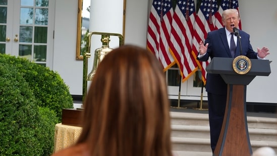 President Donald Trump speaks as Nicki Minaj listens at a lunch in the White House Rose Garden.