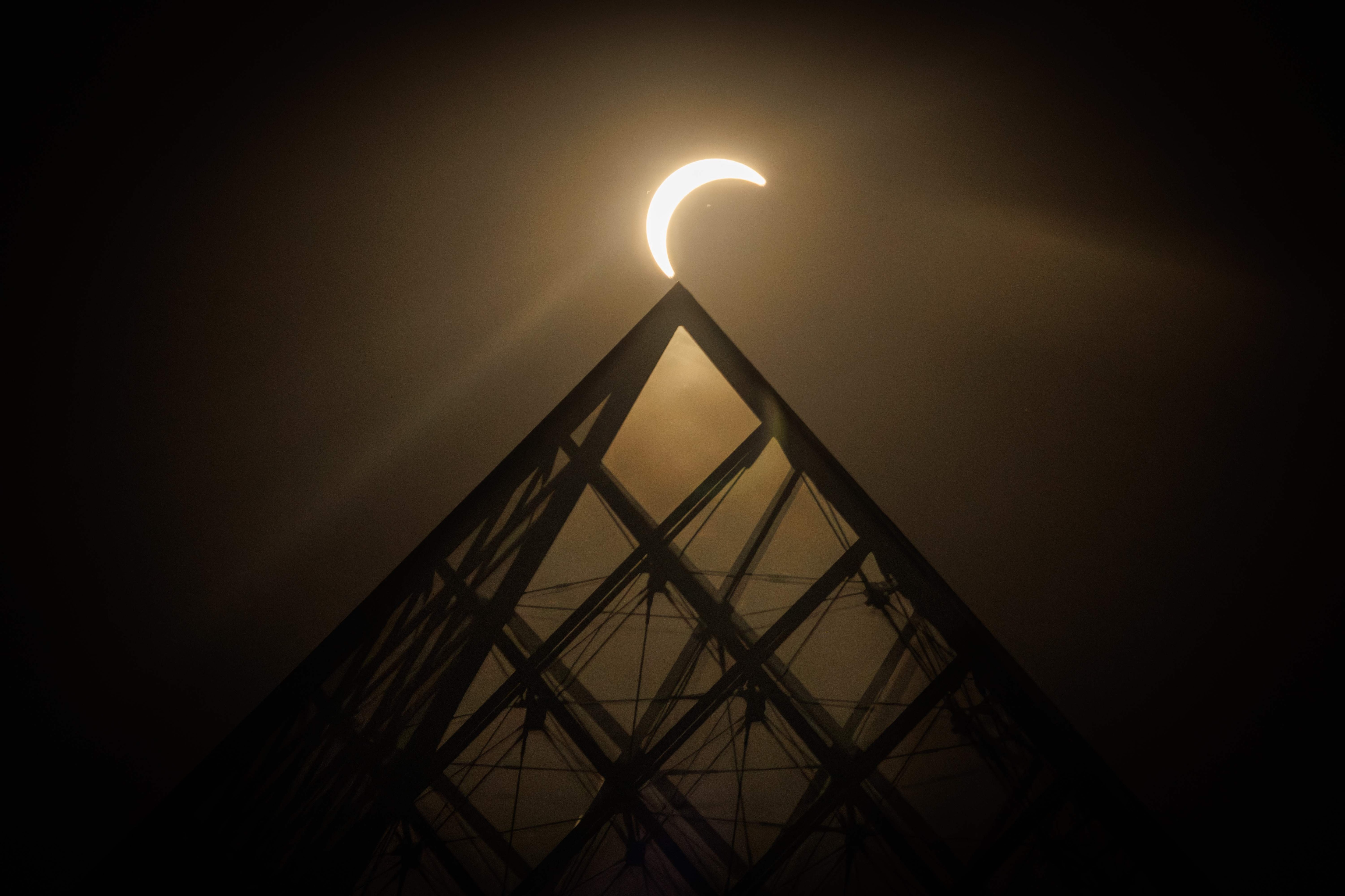 The moon passes over the sun's horizon behind the Pyramide du Louvre, designed by Chinese-US architect Ieoh Ming Pei, during a partial solar eclipse in Paris. (AFP Photo) The moon passes over the sun's horizon behind the Pyramide du Louvre, designed by Chinese-US architect Ieoh Ming Pei, during a partial solar eclipse in Paris. (AFP Photo)
