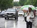 People caught in rain at Connaught Place in New Delhi on Friday. (Sanjeev Verma/Hindustan Times)