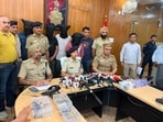 Police officials with the accused and recovered firearms addressing a press conference in Chandigarh on Thursday. (HT Photo)