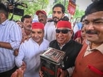 Samajwadi Party MPs Dharmendra Yadav and Awadhesh Prasad arrive at the Hanuman Temple in Connaught Place, New Delhi, to deposit money collected from different Members of Parliament during a symbolic protest in the Parliament complex, on Thursday. (Sanchit Khanna/Hindustan Times)