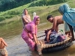 Woman and her newborn being carried across the Utangan river in Agra district on Thursday. (HT Photo)