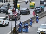 File image: Sanitation workers clean a roadside median as traffic moves along a road in Bengaluru (AFP)