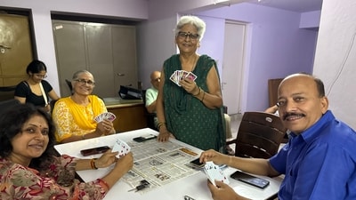Pushpa Singh stands by the table for a quick photo, holding her cards in a fan. Pushpa Singh stands by the table for a quick photo, holding her cards in a fan.