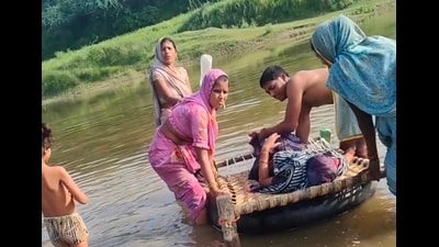 Woman and her newborn being carried across the Utangan river in Agra district on Thursday. (HT Photo) Woman and her newborn being carried across the Utangan river in Agra district on Thursday. (HT Photo)