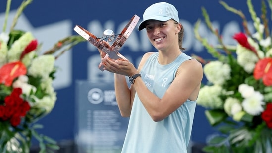 Iga Swiatek of Poland poses with the trophy after defeating Elena Rybakina of Kazakhstan.