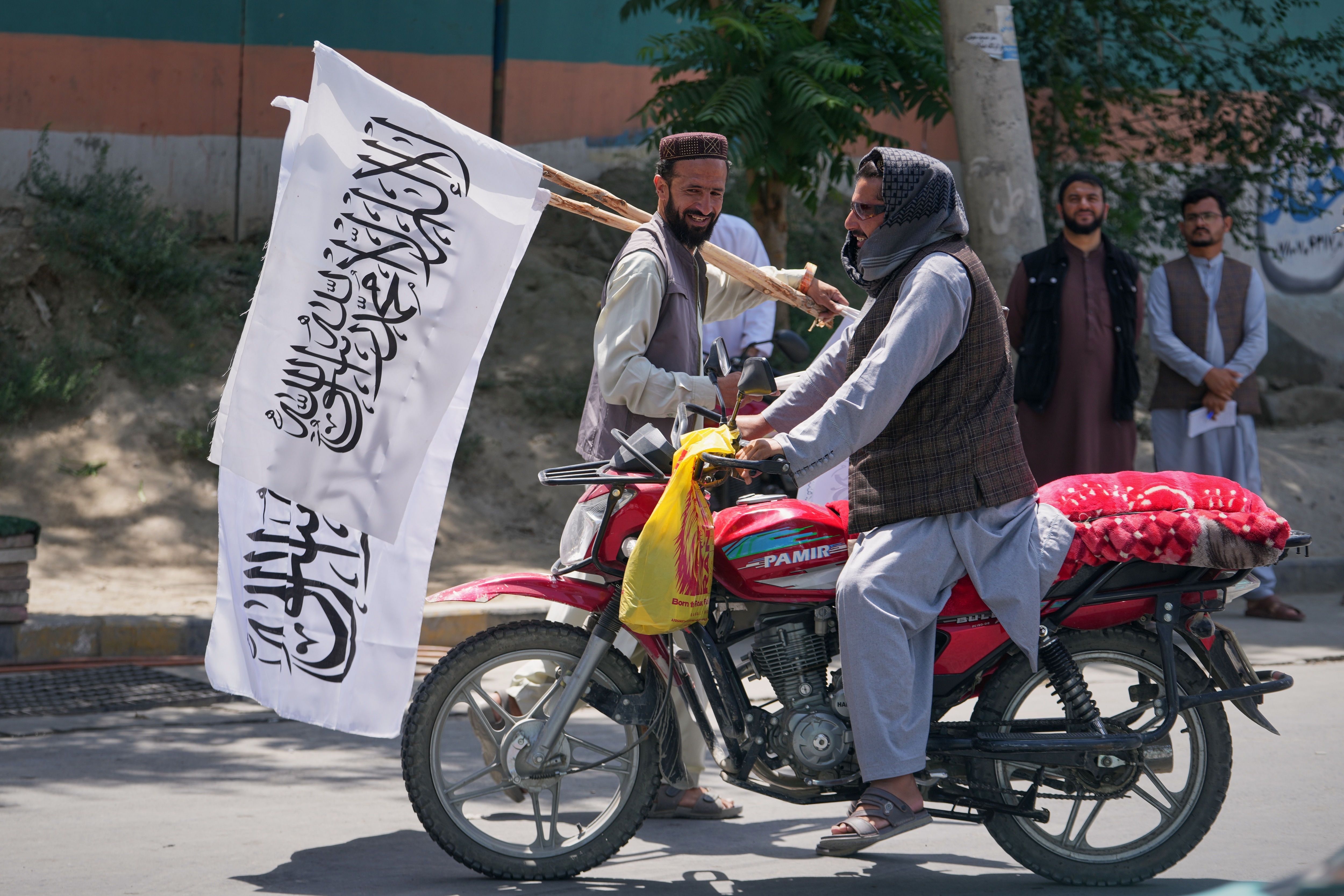 A man offers Taliban flags for sale ahead of celebrations marking the fifth anniversary of the US withdrawal from Afghanistan and the start of Taliban rule, in Kabul, Afghanistan, Aug. 13, 2026. (AP Photo/Siddiqullah Alizai)